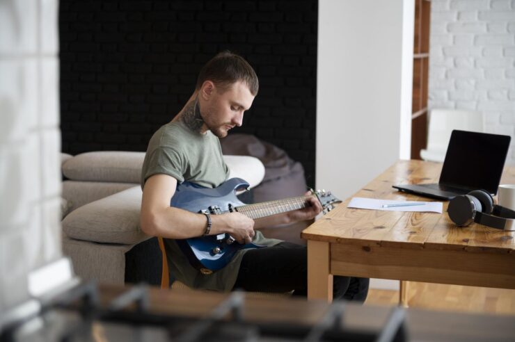 Man playing guitar at home